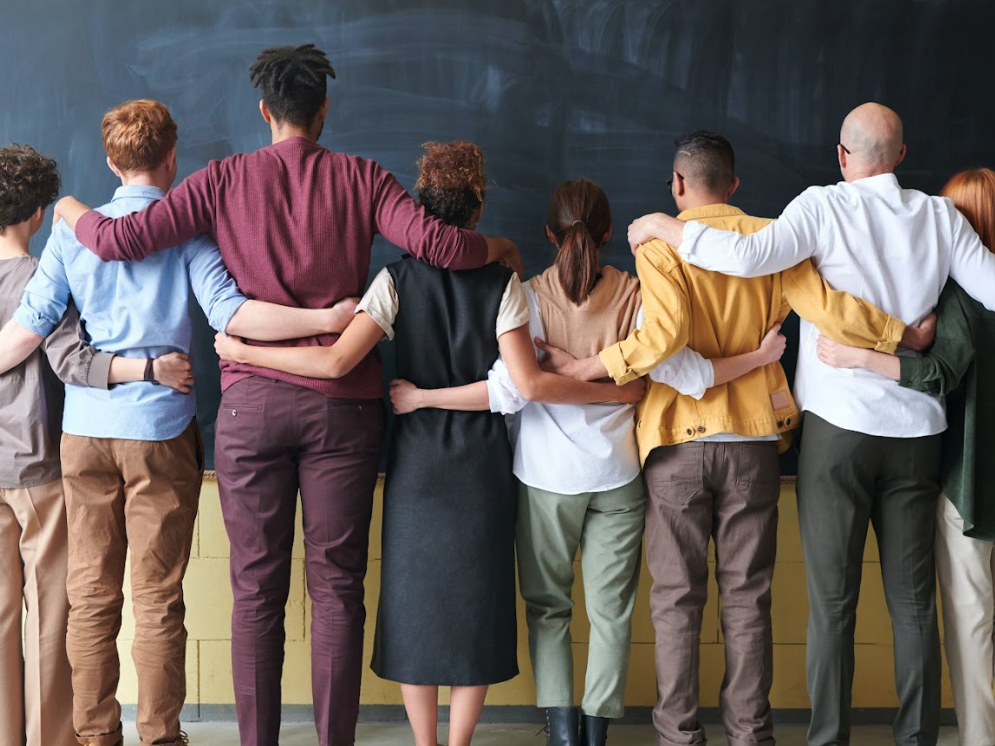 back view of a line of people with their arms around each other